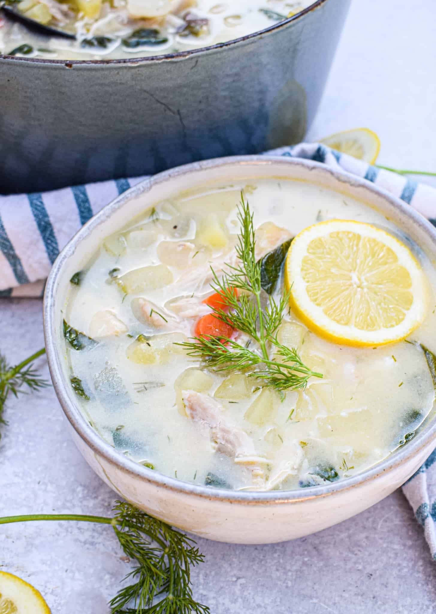 bowl of Whole30 Greek Lemon Chicken Soup with slice of lemon and fresh dill