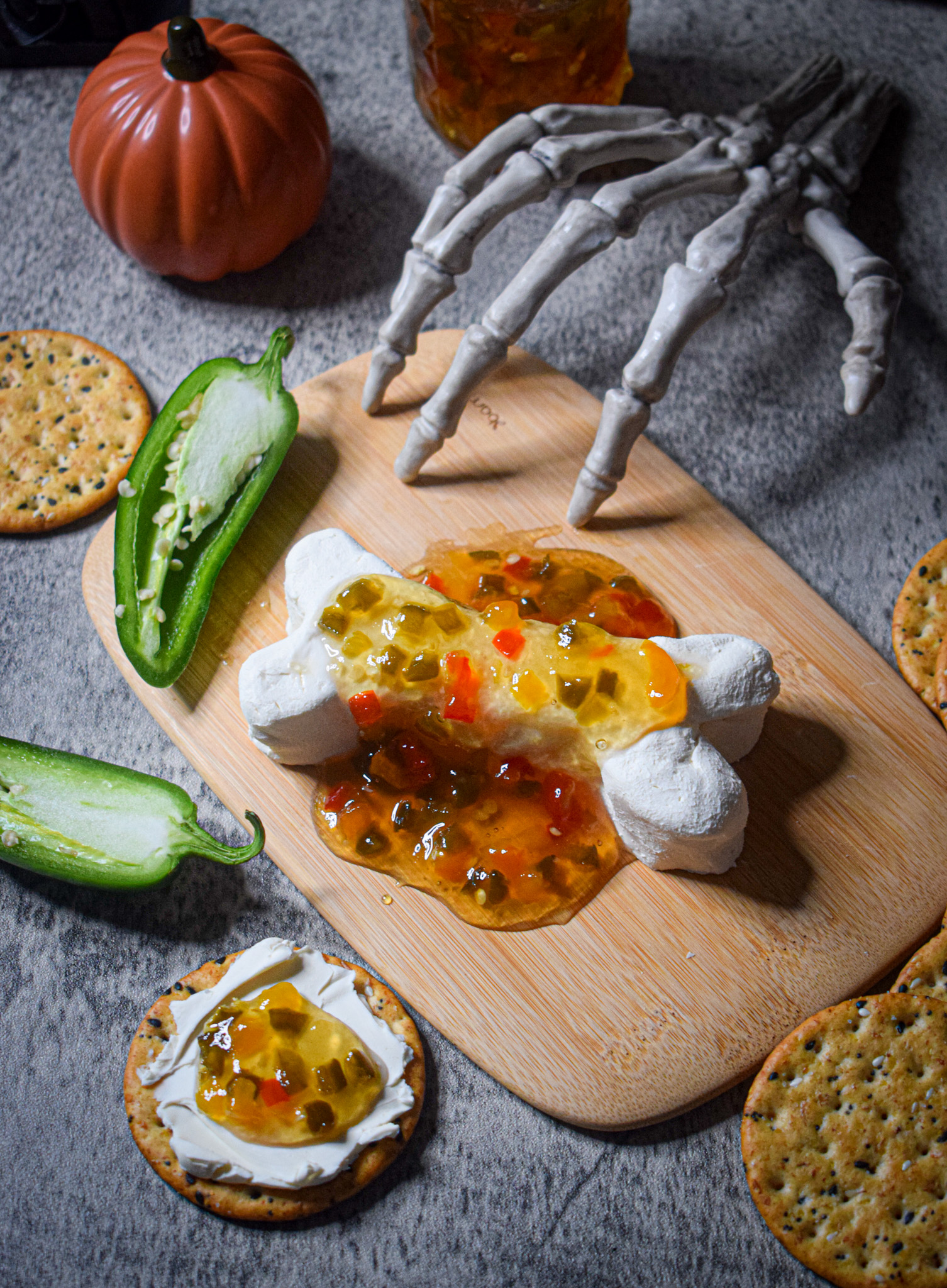 Halloween appetizer cream cheese skeleton bone with jalapeno pepper jelly and crackers 