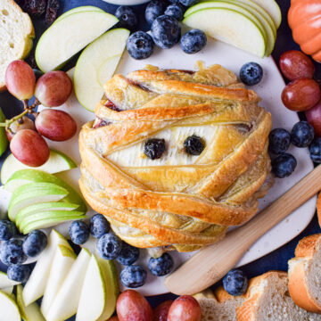 mummy brie surrounded by fruit and bread