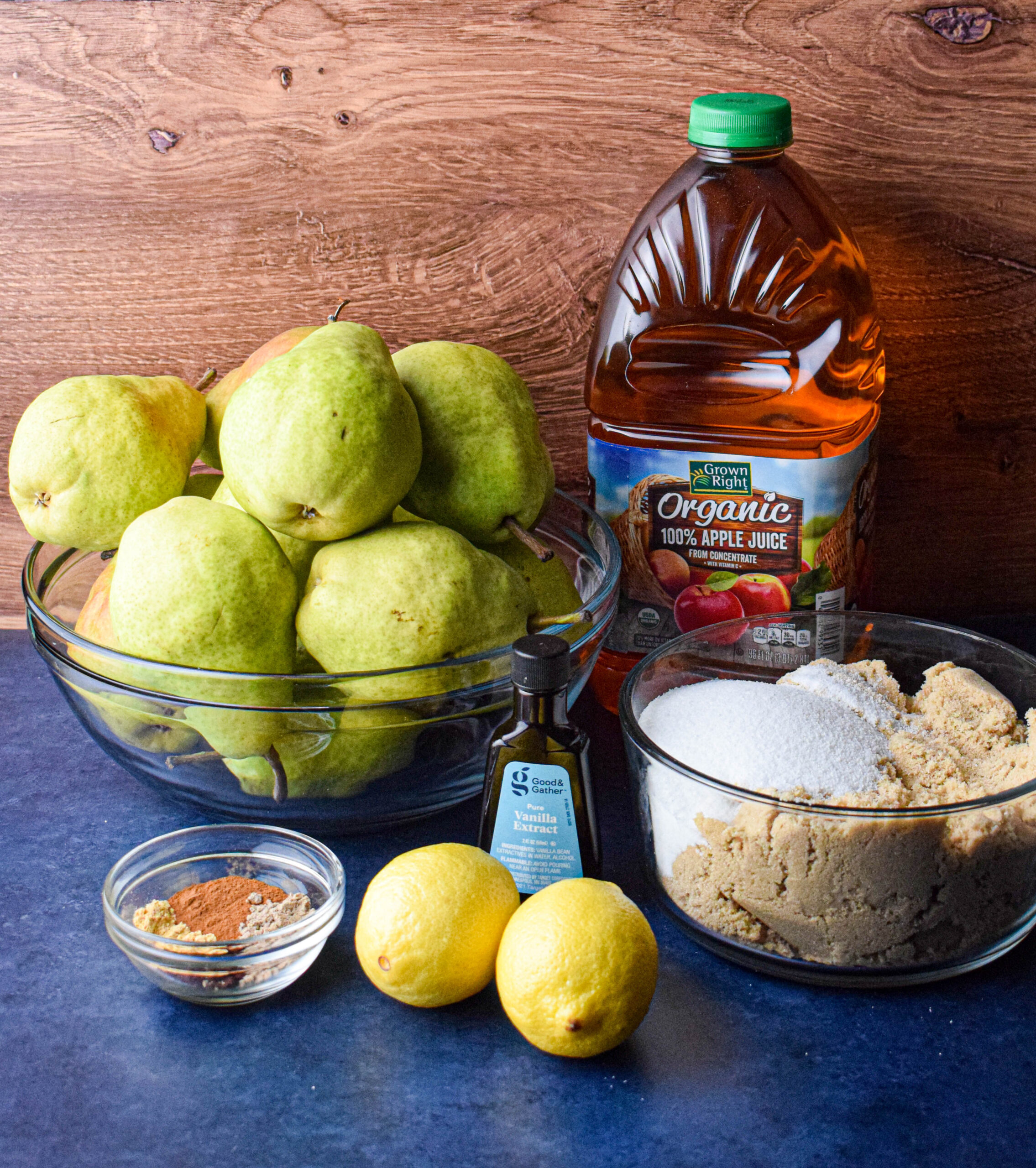 ingredients for slow cooker apple butter: green pears, apple juice, vanilla extract, spices, lemon, sugar 