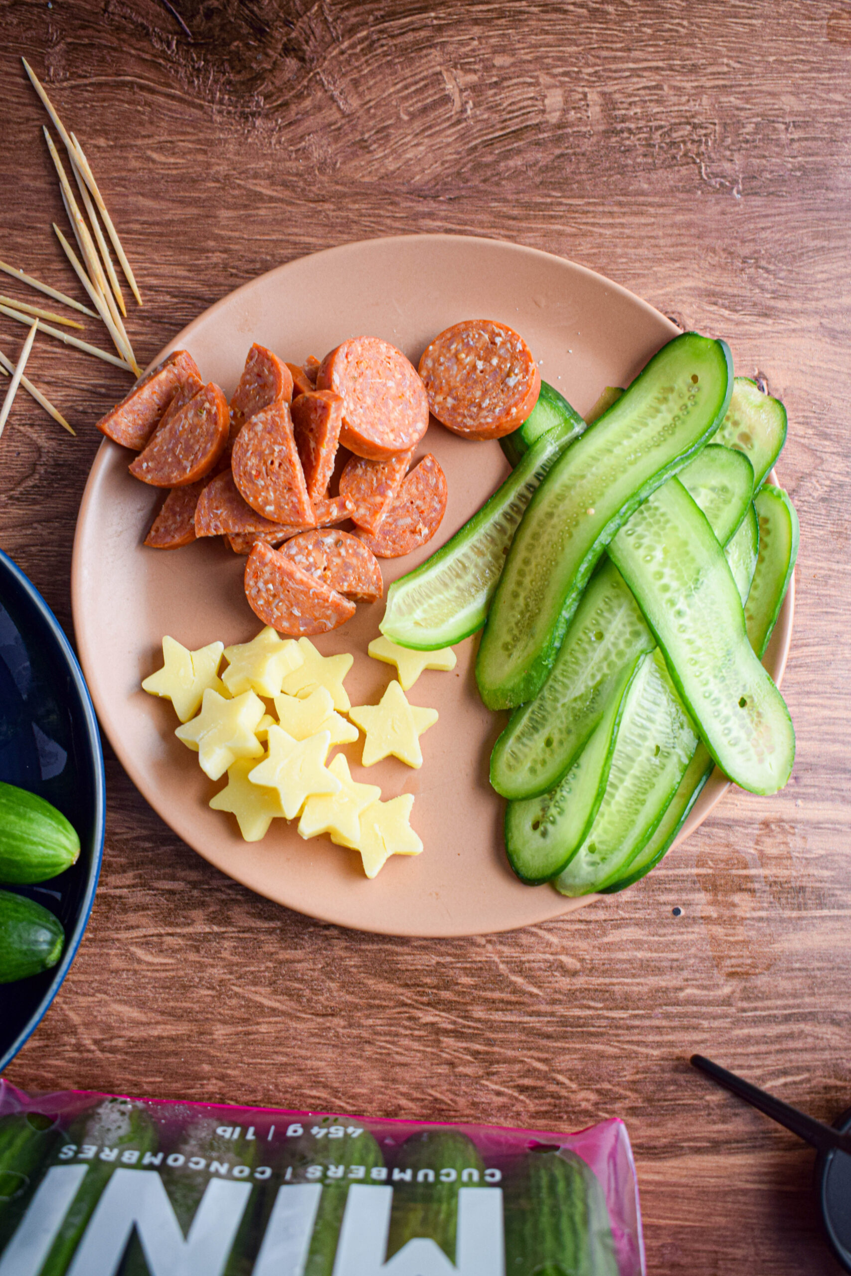 plate with cheddar cheese stars, mini cucumbers and pepperoni