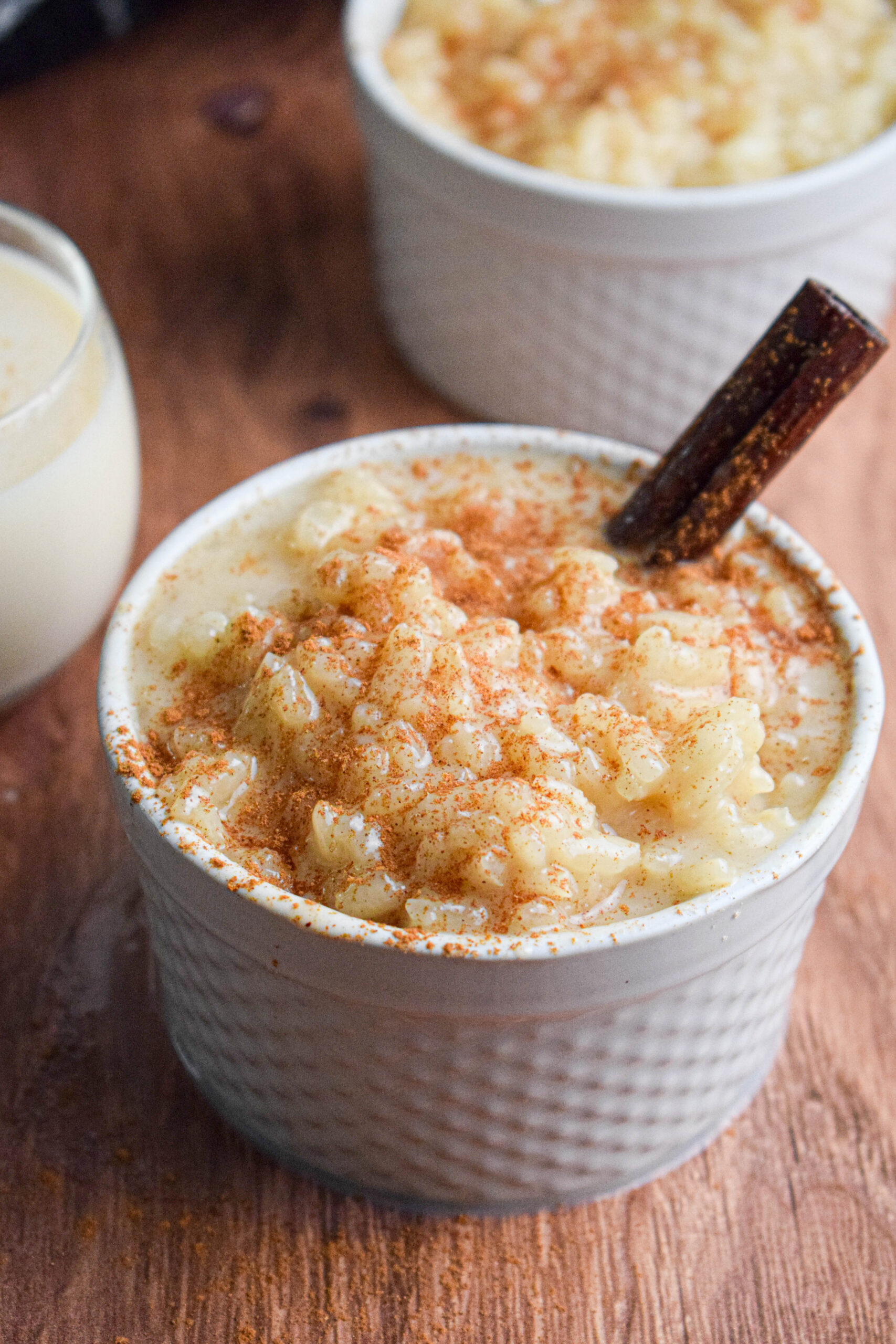 vegan rice pudding in a white dish topped with cinnamon