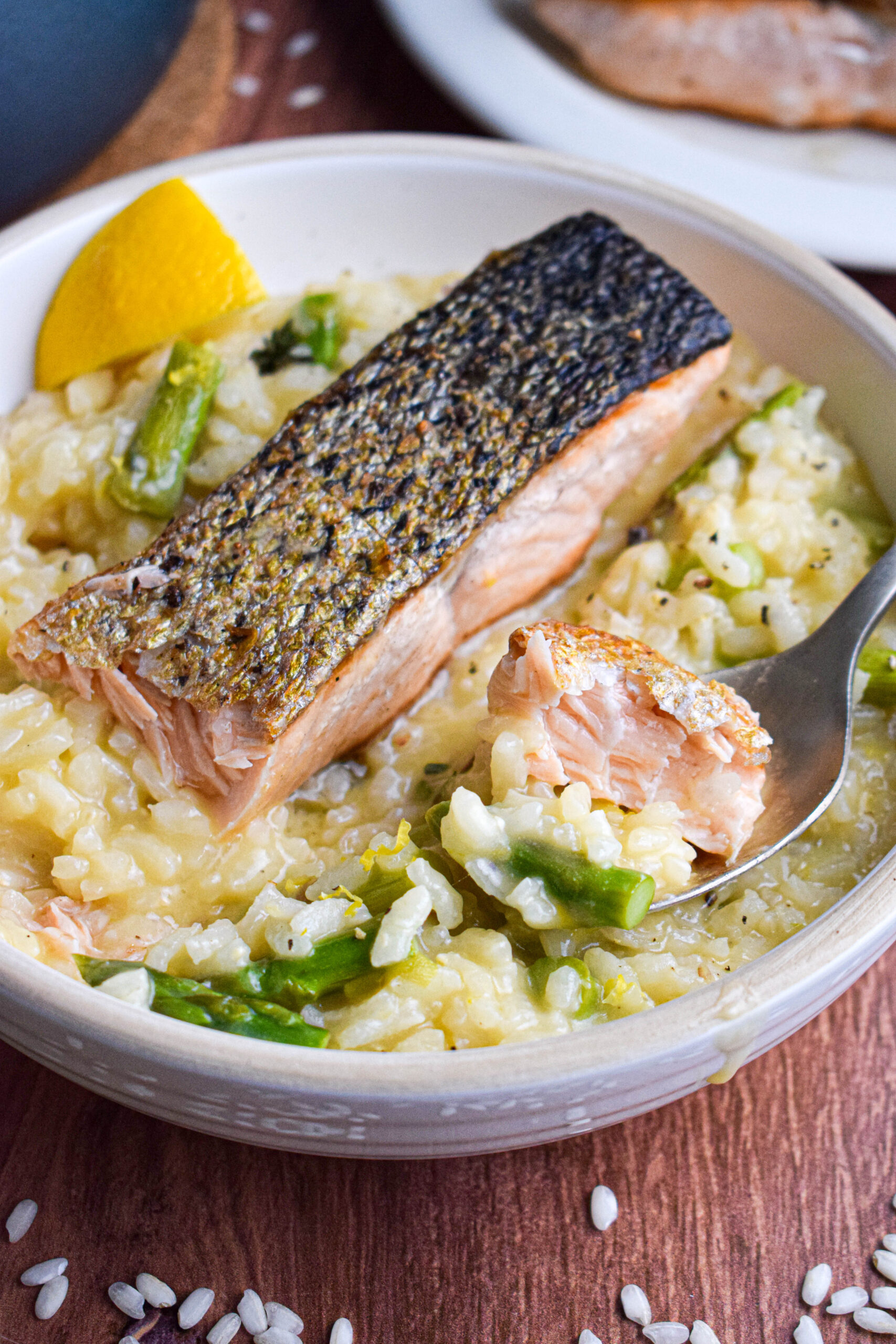 bowl of lemon parmesan asparagus risotto topped with pan seared salmon 