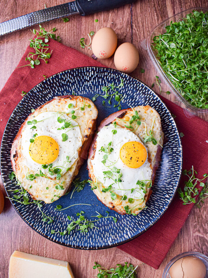 2 croque madame sandwiches topped with runny eggs