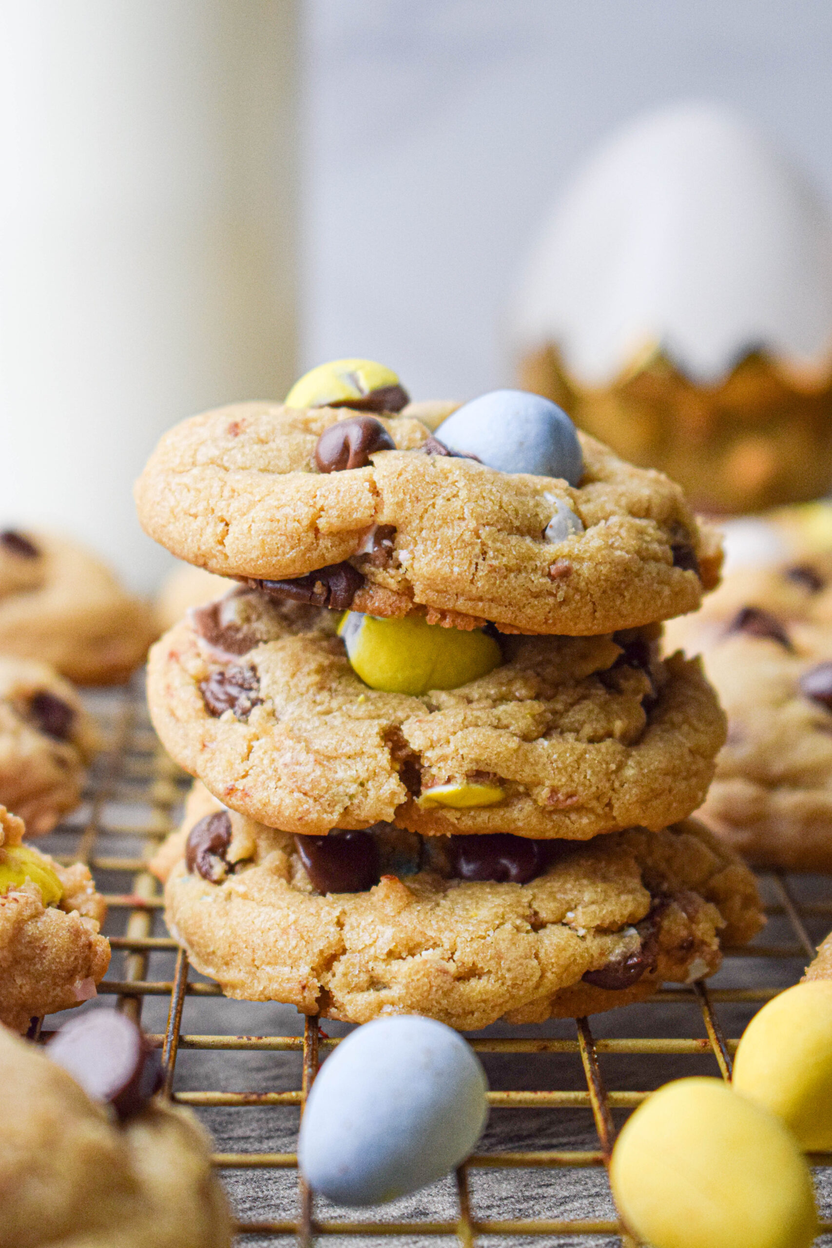 stack of 3 Easter mini egg cookies surrounded by cadbury mini eggs 