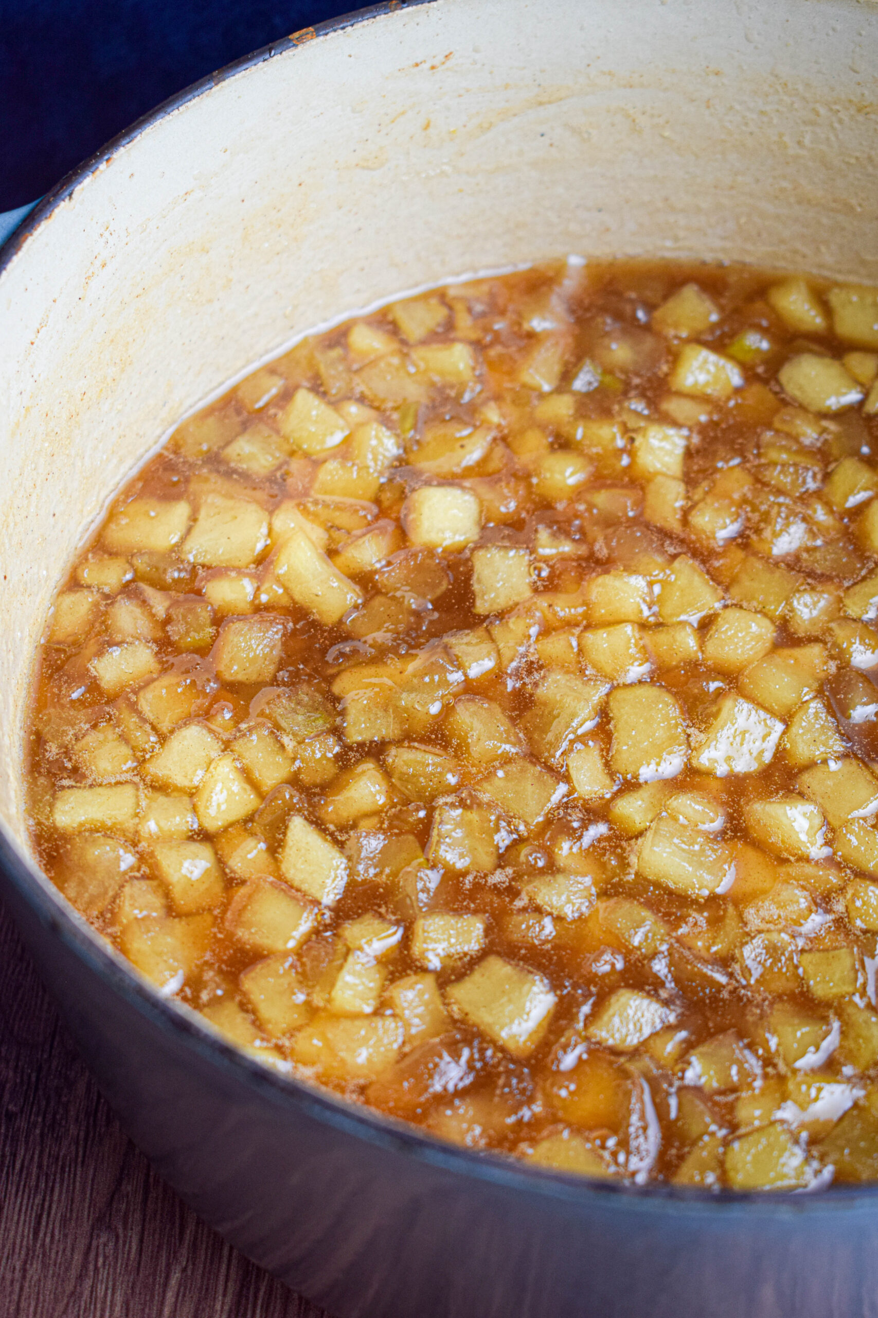 large blue dutch oven pot full of cooked apple jam 