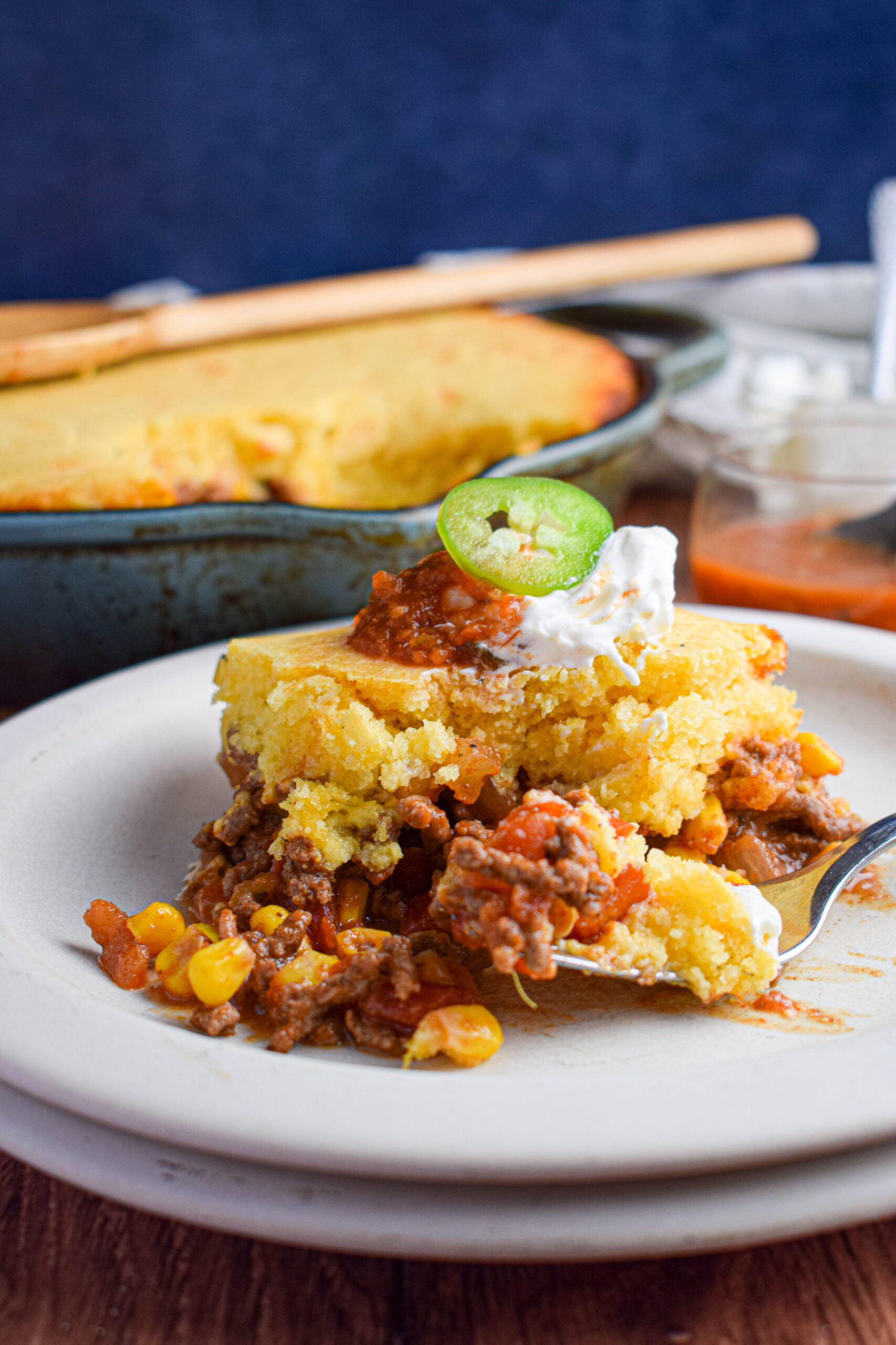 plate of tamale pie with ground beef and vegetables and a fork