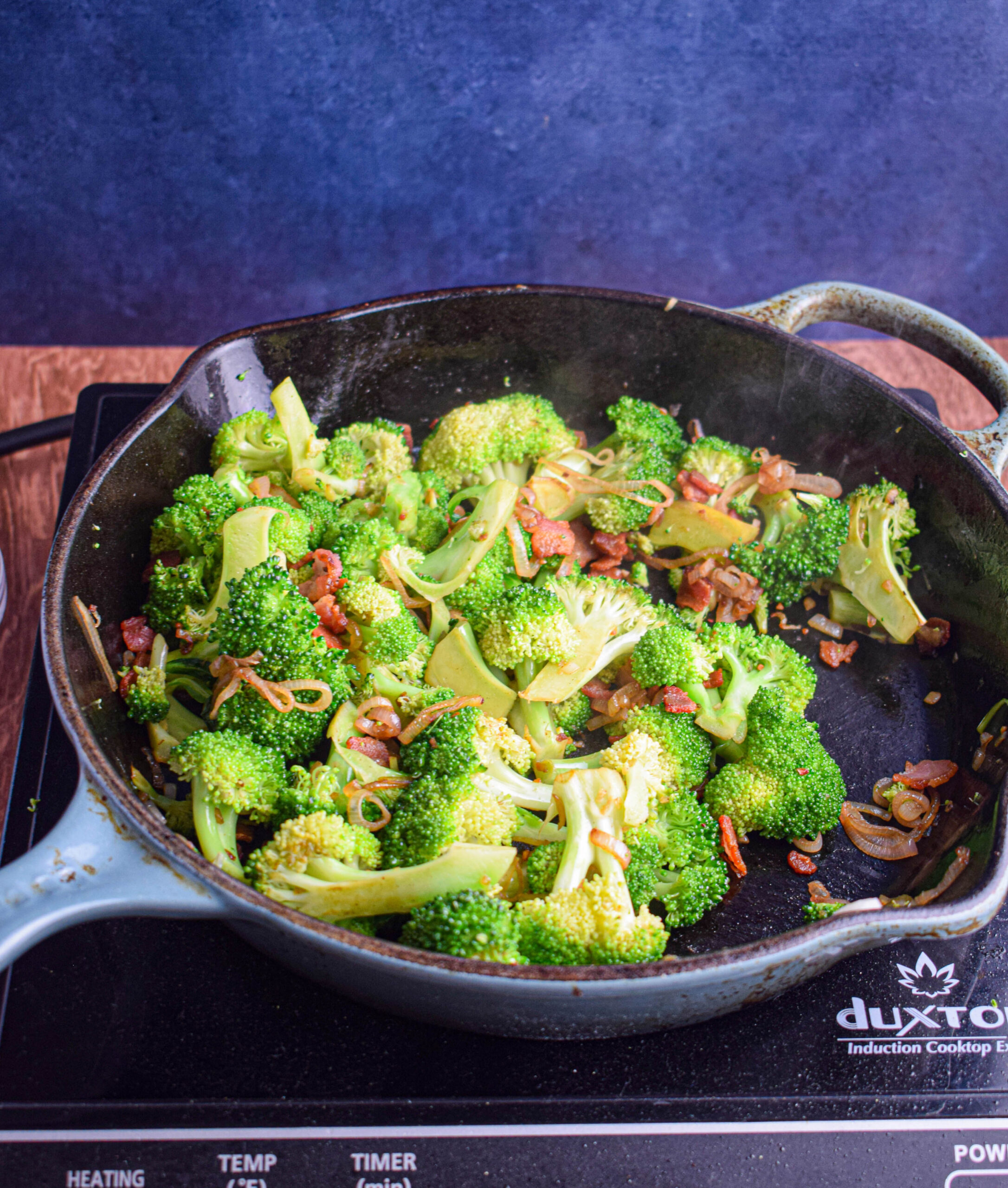 cast iron skillet with shallots broccoli and bacon