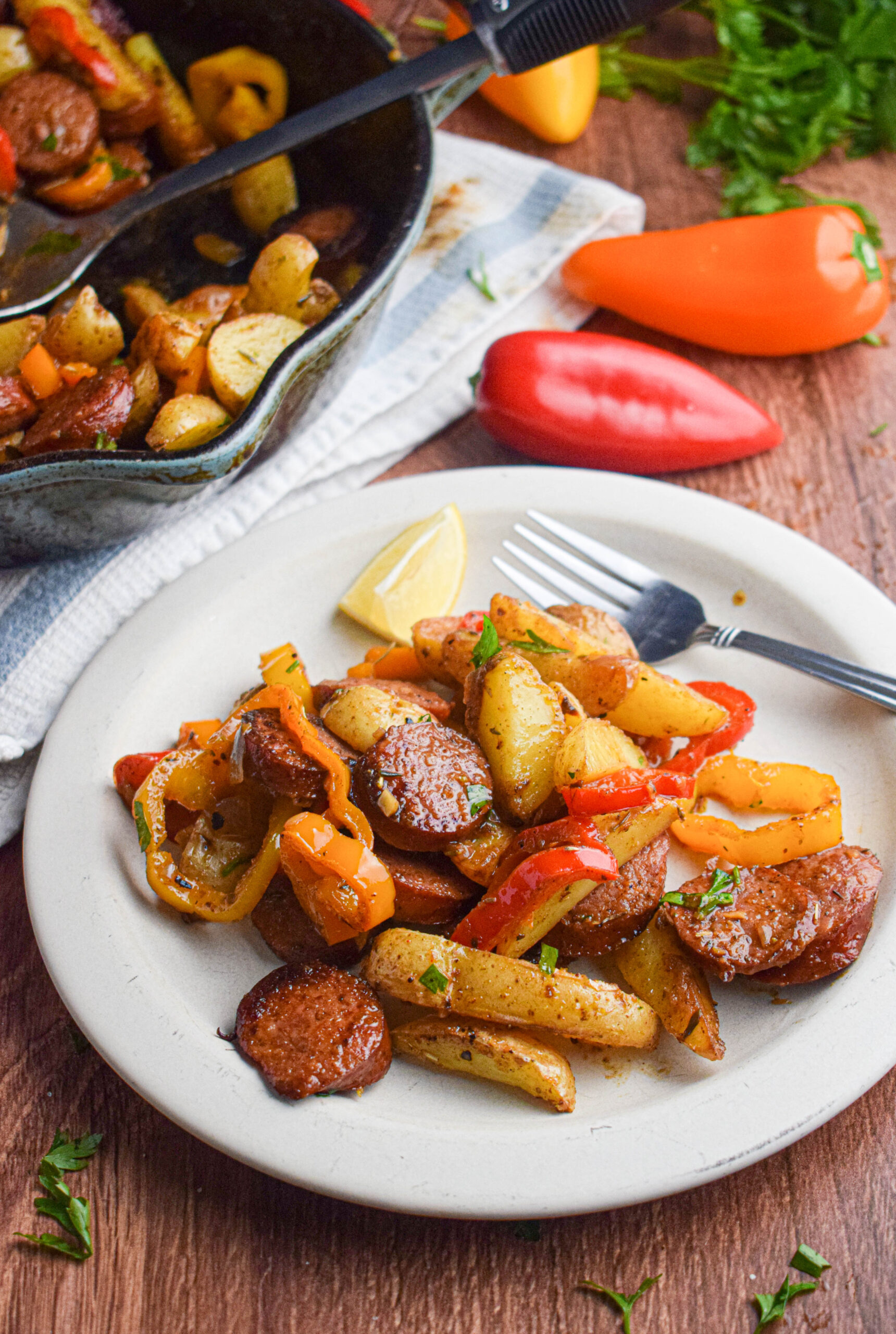 plate full of sausage, potatoes and peppers