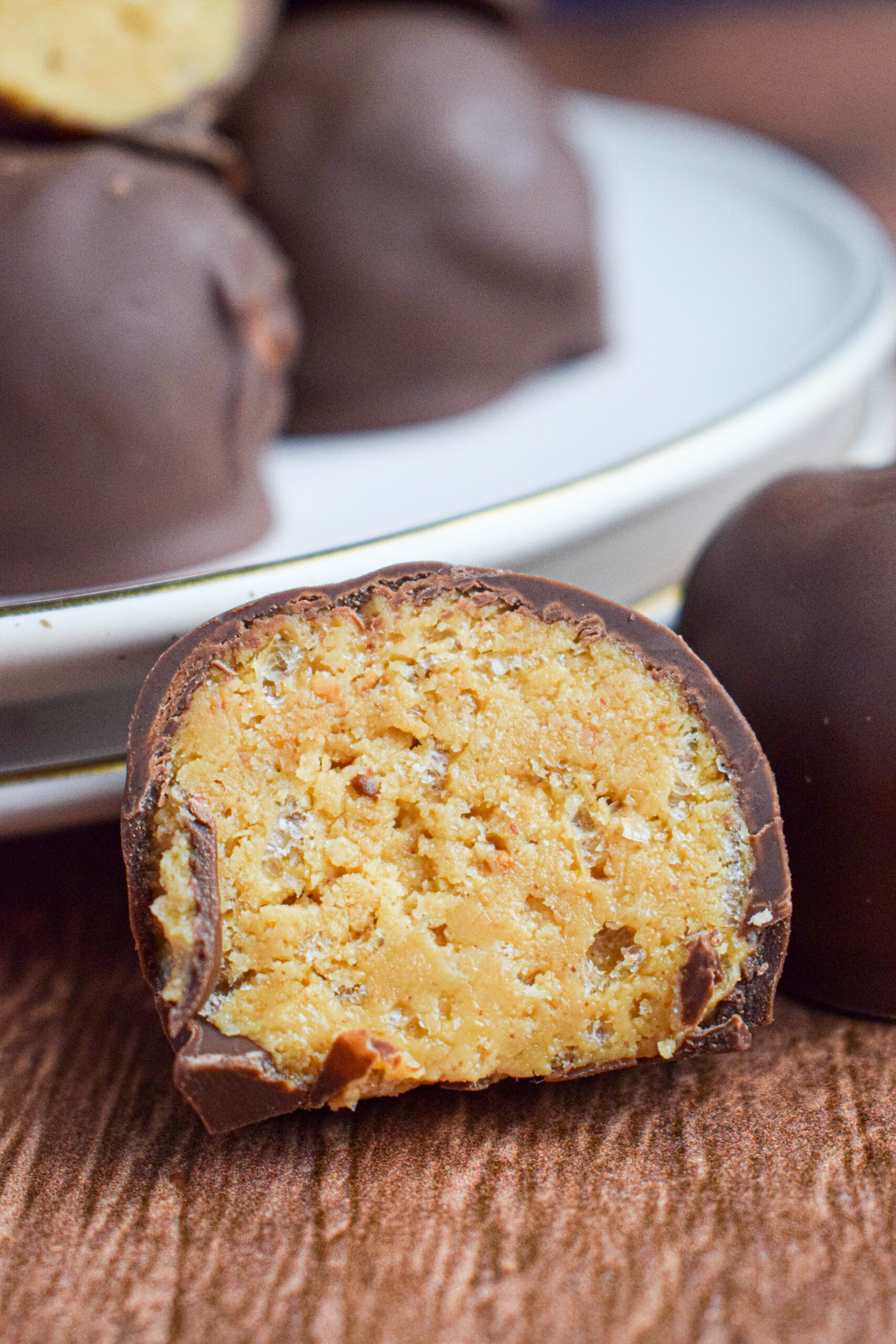 close up photo of a chocolate covered puffed rice peanut butter ball cut in half