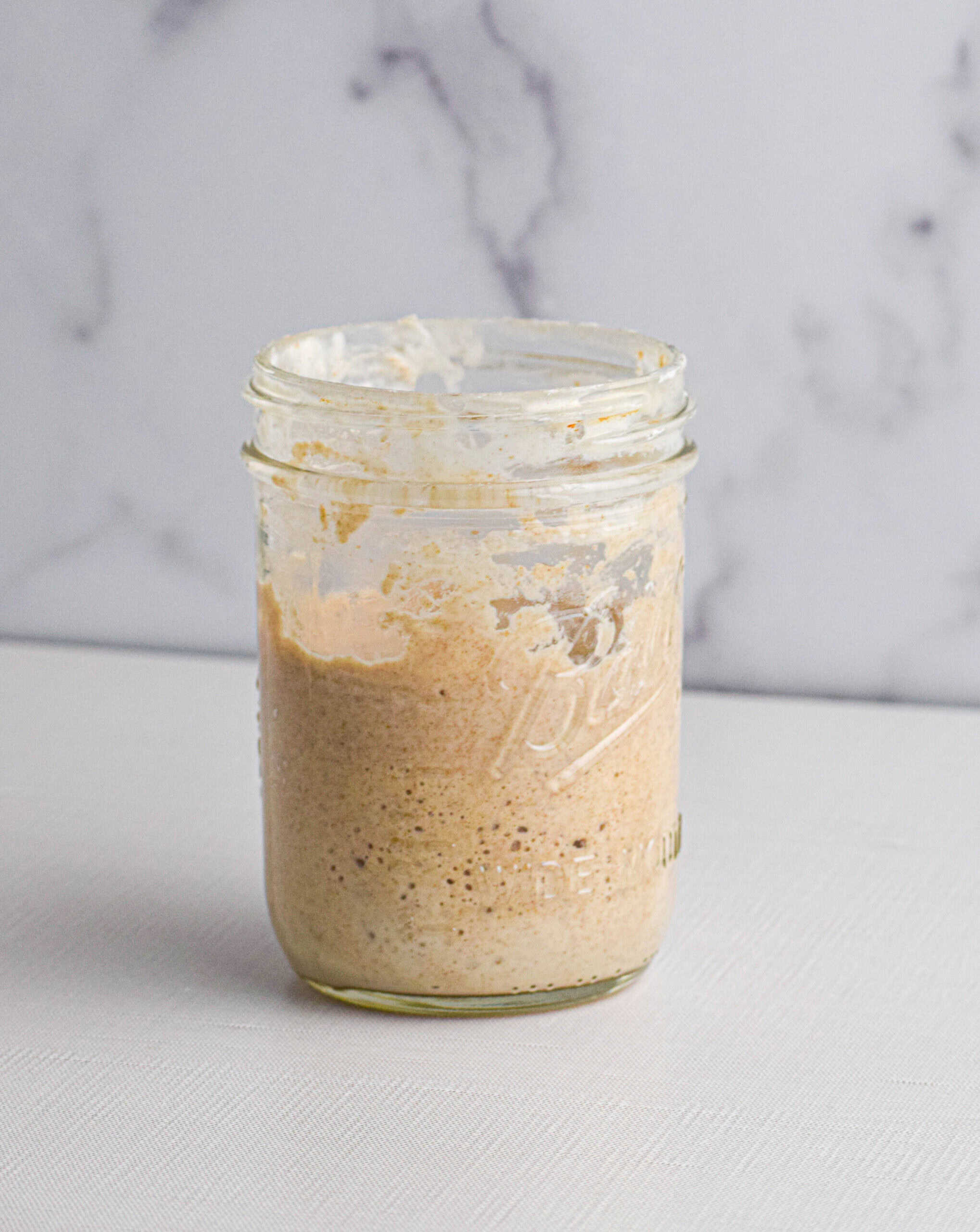 A glass mason jar of sourdough starter. 