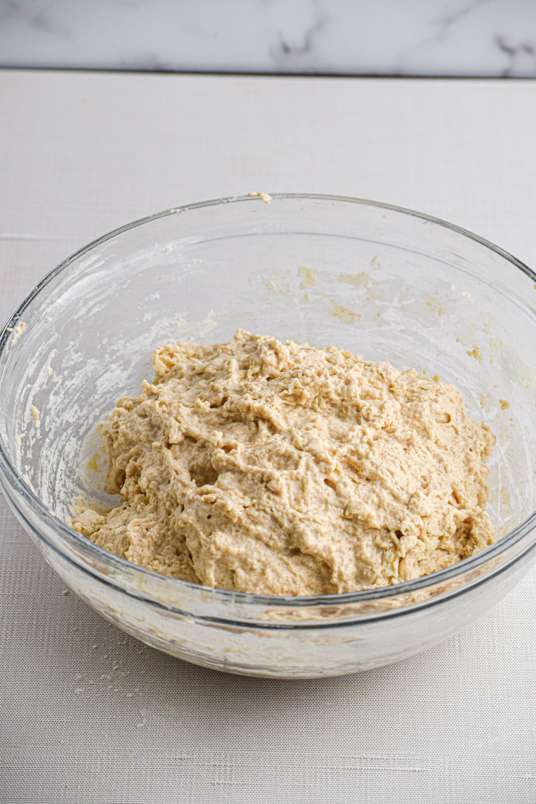 a glass bowl with a shaggy sourdough dough. 