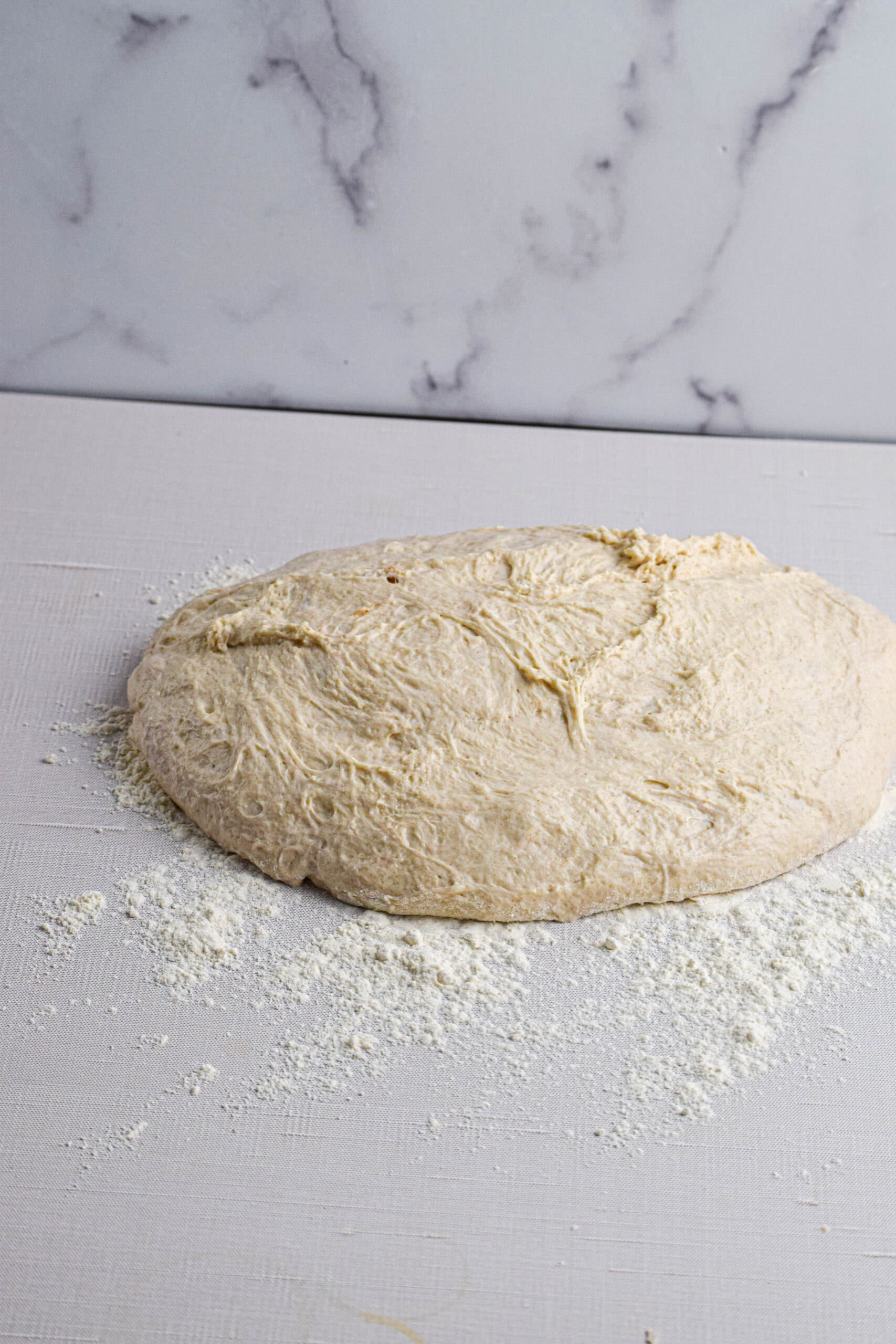 The dough has been turned out onto a floured surface and is ready to be shaped. 